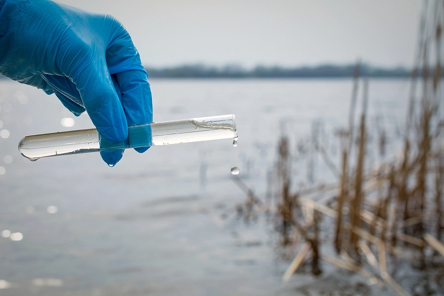 Researcher holding a test tube of Camp Lejeune water polluted with toxic chemicals