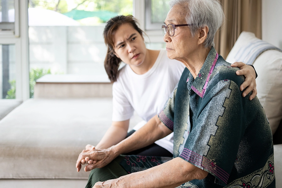 Young woman sits with grandmother with dementia or Alzheimer's connected to her military service