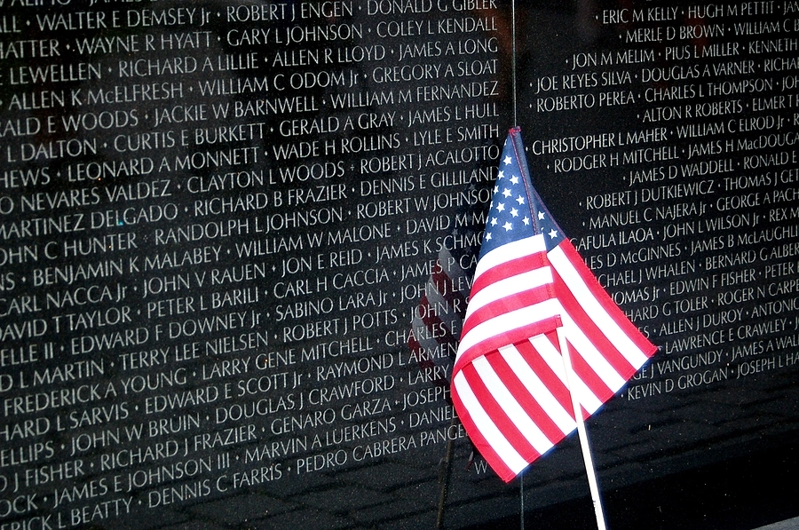 Vietnam War memorial with veterans names listed and an American flag; many were exposed to Agent Orange while serving