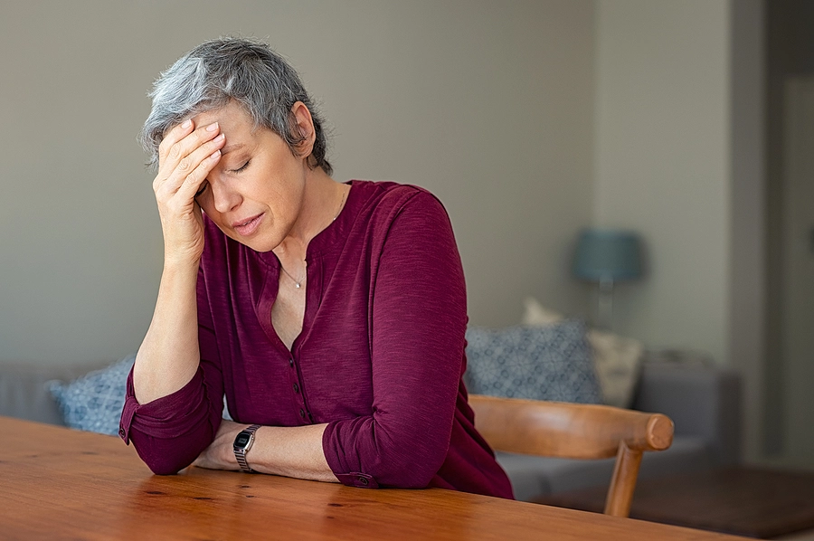 older female veteran at home with chronic migraines caused by her military service