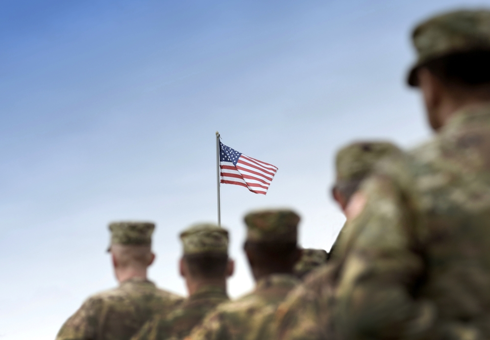 US Soldiers facing American flag - VA Individual Unemployability - Bartlett Legal Group